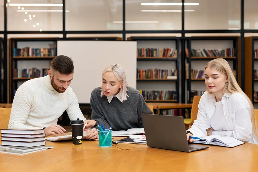 Students studying together at a table in a library