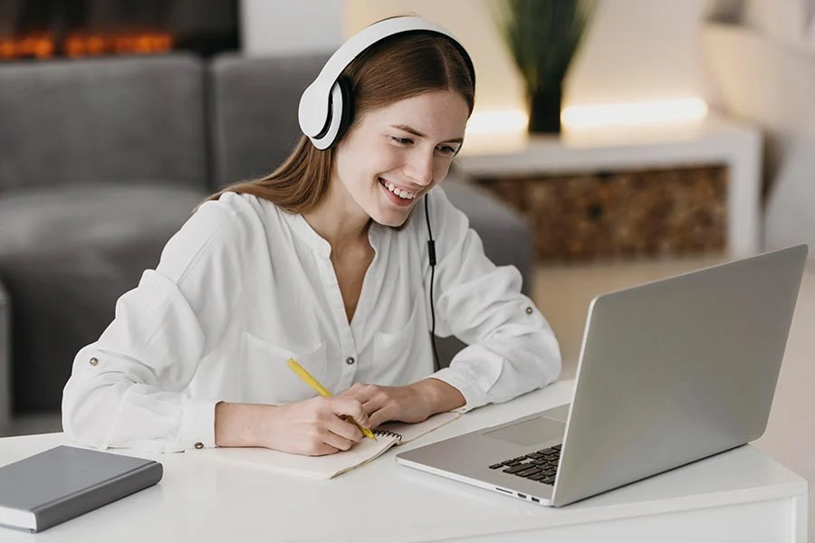Student with headphones attending an online class on a laptop